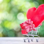 Red hearts in shopping cart. Online dating concept.